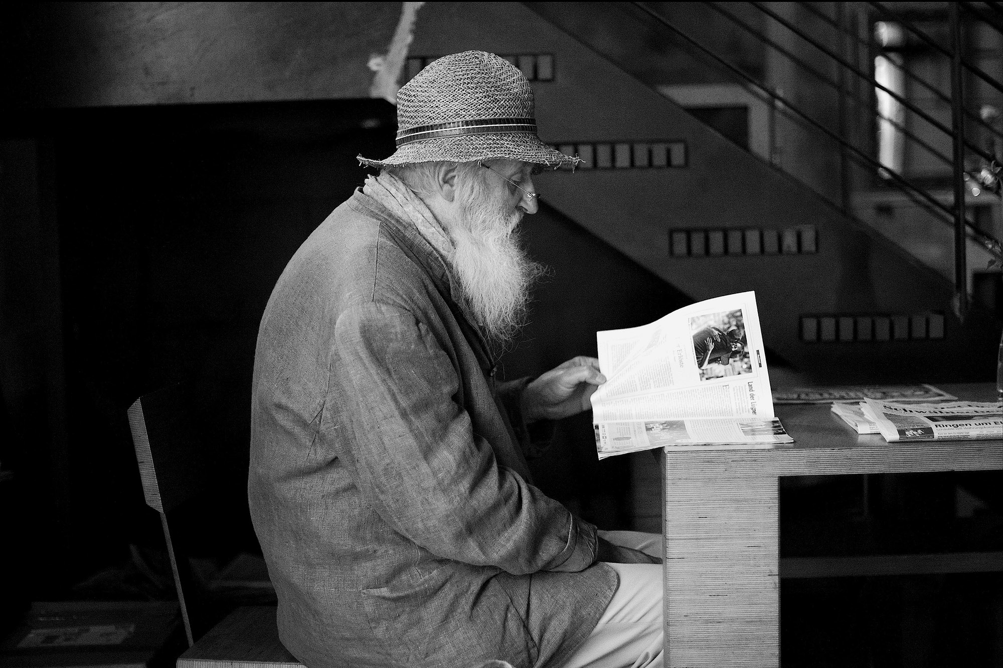 Reportagefotografie eines alten Mannes mit Zeitung