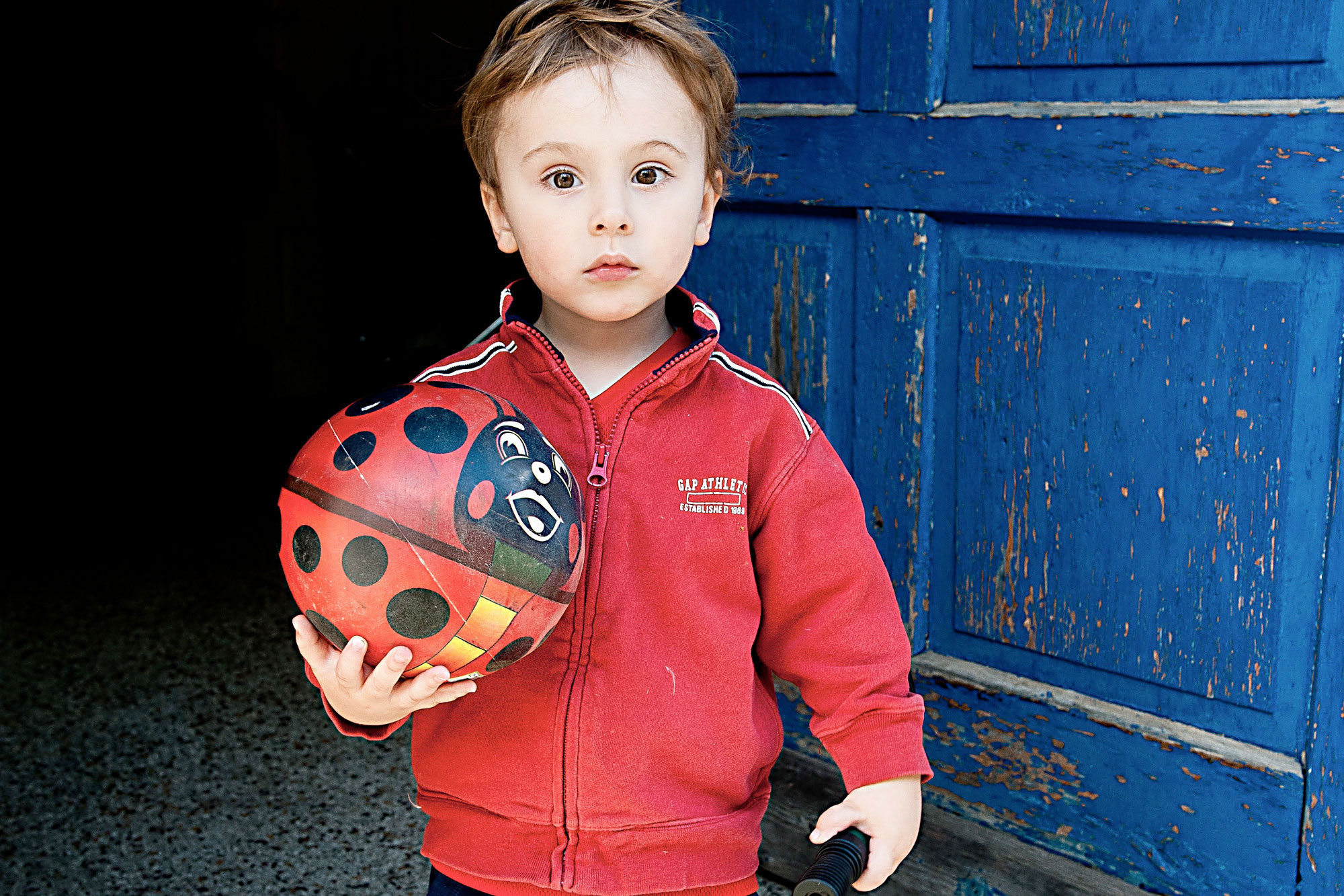 Fotografie eines kleinen Jungen mit Ball in der Hand