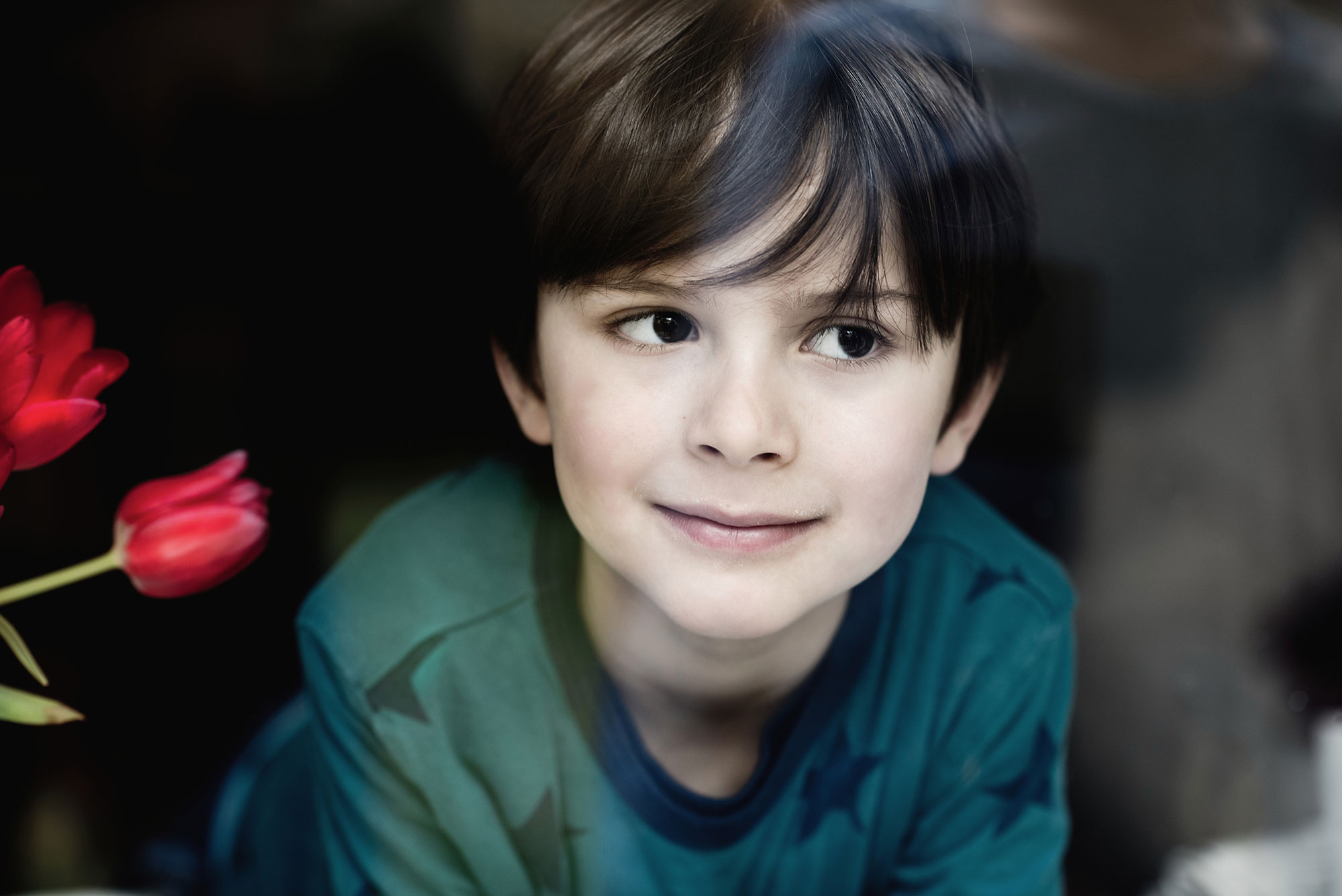 Porträtfotografie eines Jungen mit violetten Blumenhintergrund
