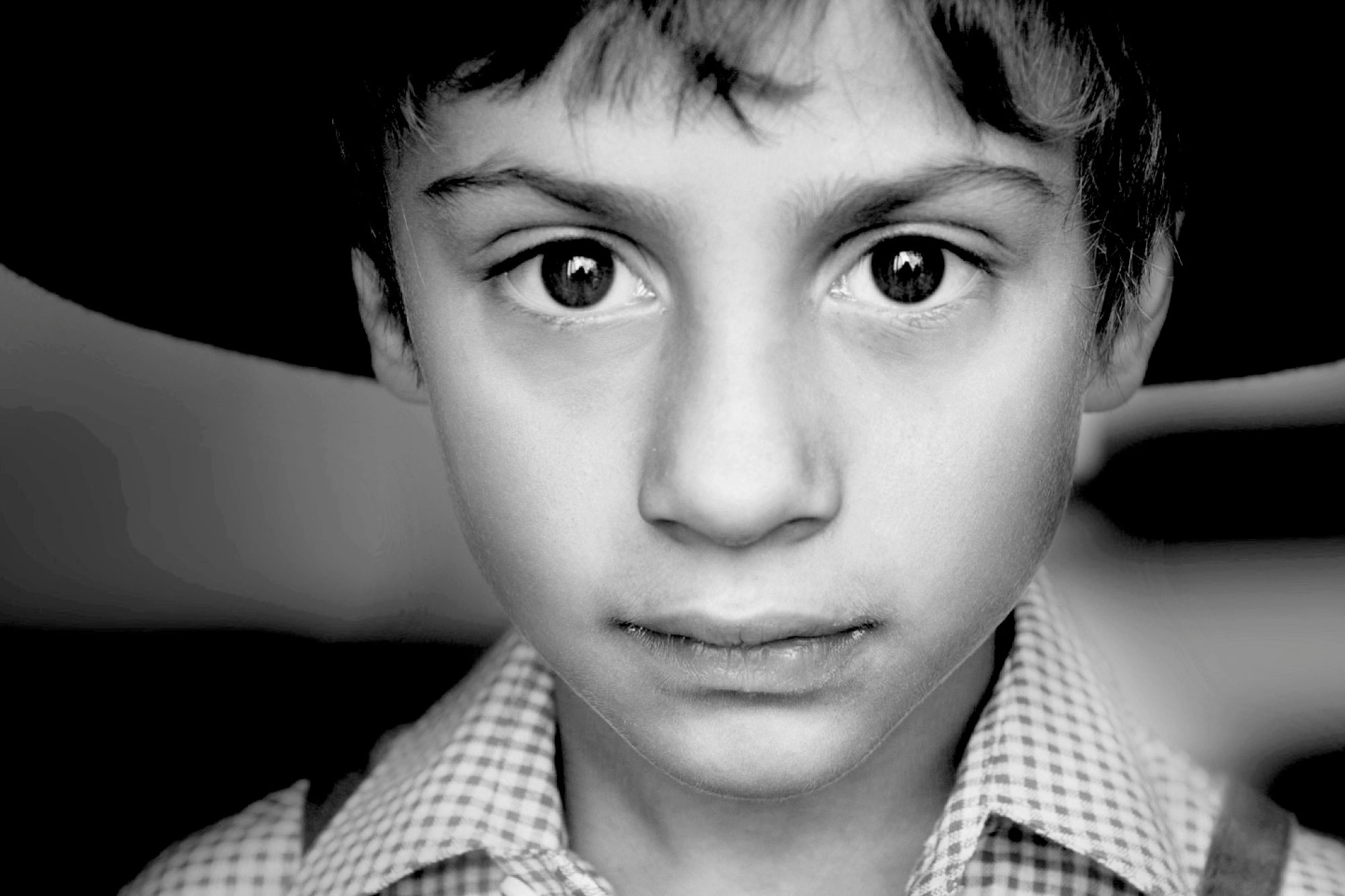 Porträtfotografie eines Jungen mit Hut (Schwarz/Weiss-Aufnahme)